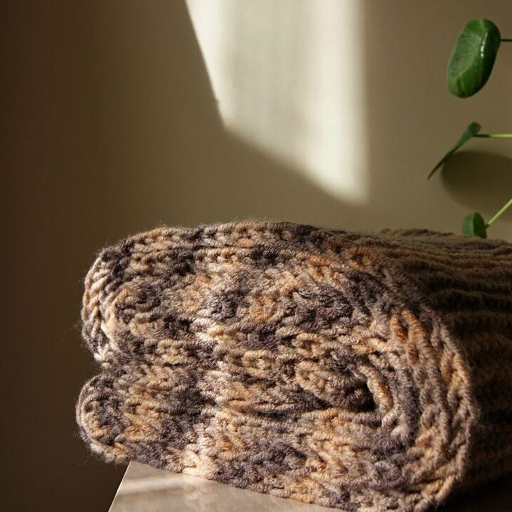 Chunky knit weighted throw folded on a bench